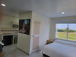 a bedroom with a bed and a large window at Cabana Acunas House in Santa Marta