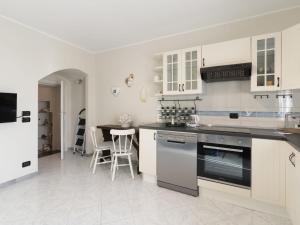 a kitchen with white cabinets and a table with chairs at Apartment il Rifugio by Interhome in Bordighera +15 photos