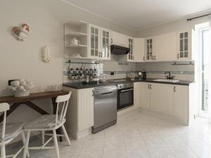 a kitchen with white cabinets and a table and chairs at Apartment il Rifugio by Interhome in Bordighera