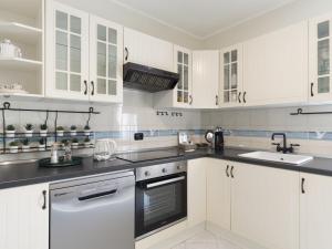 a white kitchen with white cabinets and a sink at Apartment il Rifugio by Interhome in Bordighera
