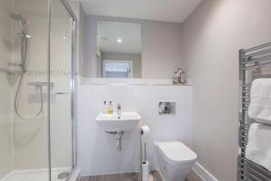 a bathroom with a shower and a sink and a toilet at Elliot Oliver - Luxury Three Bedroom Town Centre Apartment With Parking in Cheltenham