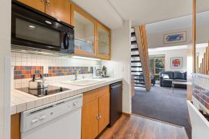 a kitchen with a sink and a microwave at Palisades Tahoe Lodge Rentals Studio Loft #314 in Olympic Valley