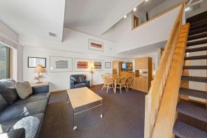 a living room with a couch and a table at Palisades Tahoe Lodge Rentals Studio Loft #314 in Olympic Valley