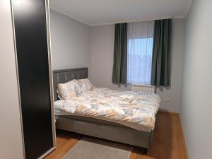 a bedroom with a bed and a large mirror at Apartman Mima in Borča