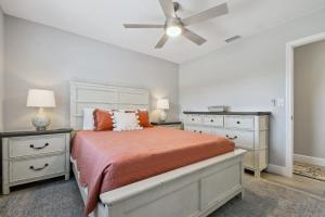 a white bedroom with a bed and a ceiling fan at Lake House Westchase area. Heated Pool Waterfront! in Tampa
