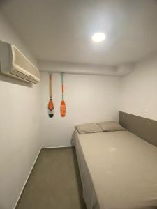 een kleine slaapkamer met een bed en keukengerei aan de muur bij FLAT TAMANDARÉ MAUI 01 in Tamandaré +6 foto's