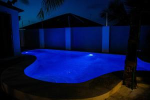 a swimming pool with blue lighting at night at Villa Kikadini in Jambiani