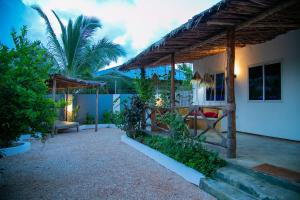 una casa con patio con palma di Villa Kikadini a Jambiani