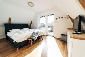a bedroom with a bed and a desk and a television at Charmantes Stadthaus in Husum