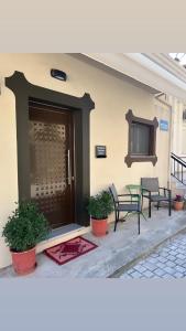 una casa con 2 sillas, una mesa y una puerta en Meteora Sunrise en Kalambaka