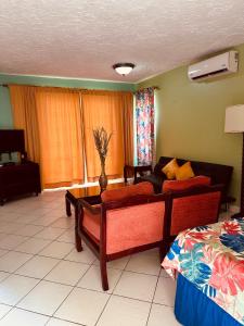 a living room with a couch and a bed at Simply Mystical in Ocho Rios