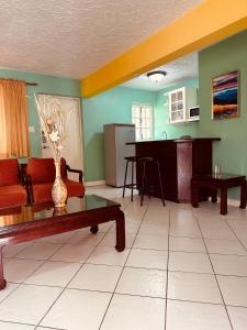 ein Wohnzimmer mit einem Sofa und einem Tisch in der Unterkunft Simply Mystical in Ocho Rios