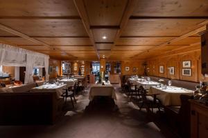 a dining room with tables and chairs and wooden ceilings at Hotel Zum Ochsen in Schonwald im Schwarzwald