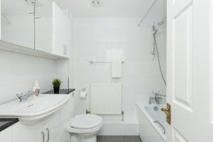 a white bathroom with a toilet and a sink at Charming 1BR flat, Canning Town, ExCel, City Hall in London