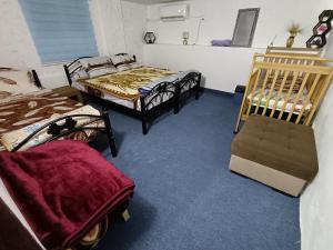 a room with three beds in a room at Rousan House in Um Qeis