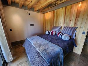 a bedroom with a bed in a room with wooden walls at Le Petite Chalet Mazamitla in Mazamitla
