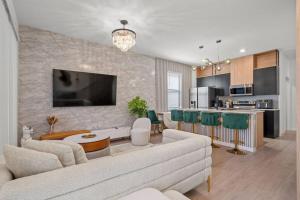 sala de estar con sofá blanco y cocina en Luxury Townhouse All Suite Near Disney Universal, en Kissimmee