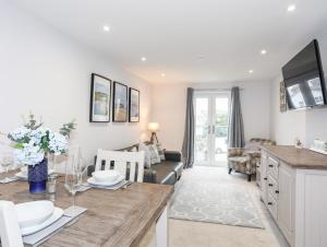 a kitchen and living room with a table and a couch at Sea Breeze in Benllech