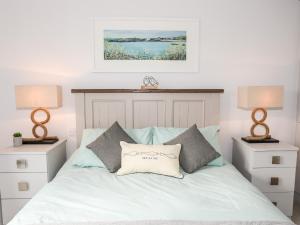 una camera con un letto bianco con due comodini di Sea Breeze a Benllech
