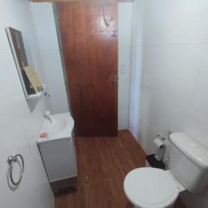 een badkamer met een toilet en een houten deur bij Cabaña El Mar in Barra del Chuy