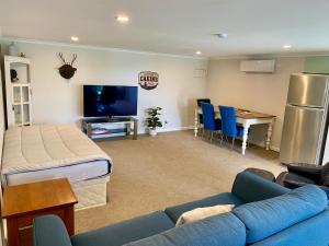a living room with a blue couch and a table at Churchill Oasis by the sea in Tauranga