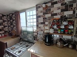 a kitchen with a stove and a counter top at Rousan House in Um Qeis