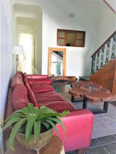 a living room with a red couch and a table at Comoda habitacion con baño privado morelos 1 in Querétaro