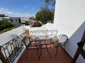 stół i 2 krzesła na balkonie w obiekcie Comoda habitacion con baño privado morelos 1 w mieście Querétaro