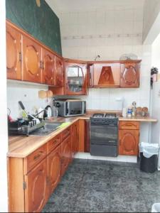 a kitchen with wooden cabinets and a stove top oven at Comoda habitacion con baño privado morelos 1 in Querétaro