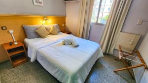 a bedroom with a large white bed and a window at Hotel Juan B Justo in Mendoza