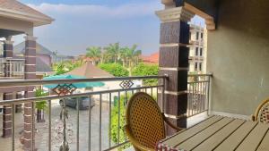 a balcony with a wooden bench and an umbrella at Royals 2 bedrooms Luxury in Accra