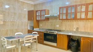 a kitchen with a table and chairs and a stove at Royals 2 bedrooms Luxury in Accra