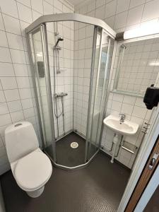 a bathroom with a shower and a toilet and a sink at Tune Hotell Sarpsborg in Sarpsborg
