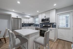 uma cozinha com armários brancos e uma mesa e cadeiras em Modern LUX 3BR Updated Townhome w/ Parking em Washington