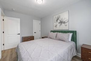 um quarto branco com uma cama com uma cabeceira verde em Modern LUX 3BR Updated Townhome w/ Parking em Washington