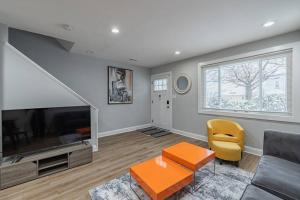 uma sala de estar com um sofá e uma televisão em Modern LUX 3BR Updated Townhome w/ Parking em Washington