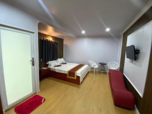 a bedroom with a bed and a red chair at Motel Happy House 2 in Bạc Liêu