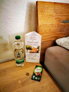 ein Buch und eine Flasche auf einem Tisch neben einem Bett in der Unterkunft Landhaus Herdt in Lauda-Königshofen