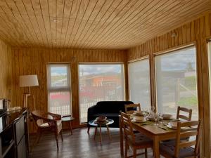 a living room with a table and chairs and a couch at AncudLodge in Ancud