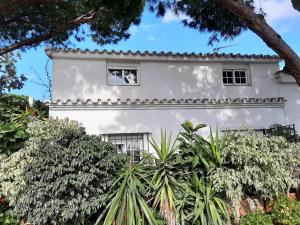 une maison blanche avec des arbres devant dans l'établissement Casa Polo, à Marbella