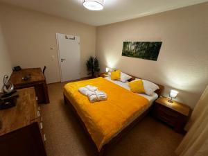 een slaapkamer met een groot geel bed met handdoeken erop bij CATS Home in Bottrop