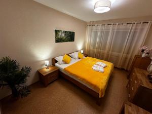 een slaapkamer met een bed met gele lakens en handdoeken bij CATS Home in Bottrop