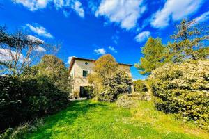 an old house on a grassy hill with trees at Adam House - Exc Pool in Marzolini