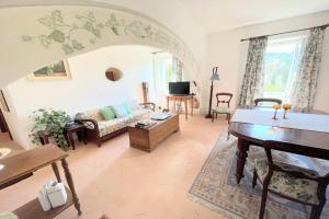 uma sala de estar com um sofá e uma mesa em Adam House - Exc Pool em Marzolini