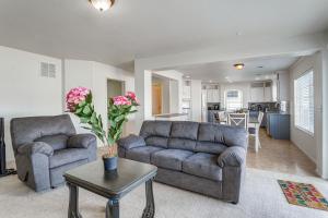 a living room with two couches and a table at Spacious Home with Patio Near Denver Airport in Aurora