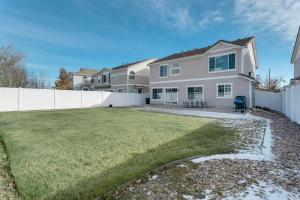 a house with a white fence and a yard at Spacious Home with Patio Near Denver Airport in Aurora