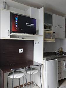 cocina con mesa con 2 sillas y TV en B1415 Flat próx a esplanada dos ministérios, en Brasilia 11 fotos más