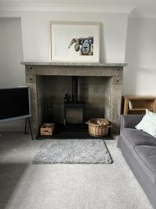 a living room with a fireplace and a couch at Apple Cottage in Newton Stewart
