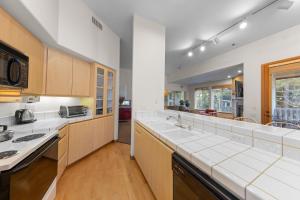 a kitchen with white counter tops and wooden cabinets at Palisades Tahoe Lodge Rentals Two Bedroom #521 in Olympic Valley