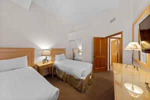 a hotel room with two beds and a sink at Palisades Tahoe Lodge Rentals Two Bedroom #521 in Olympic Valley +13 photos